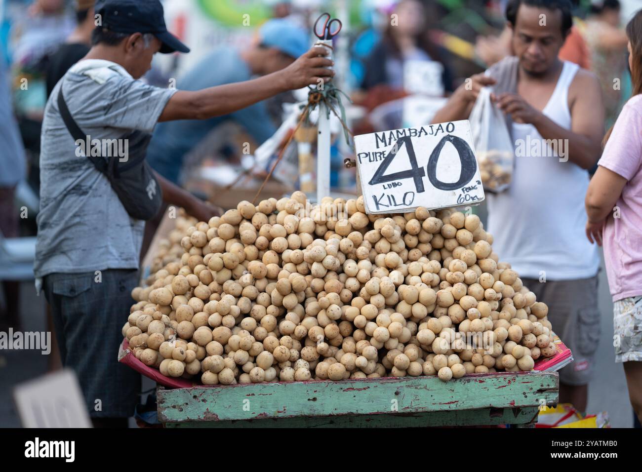 12/10/2024 Cebu City, Philippinen. Ein Straßenverkäufer, der die beliebten Obst-Lanzones verkauft. Stockfoto