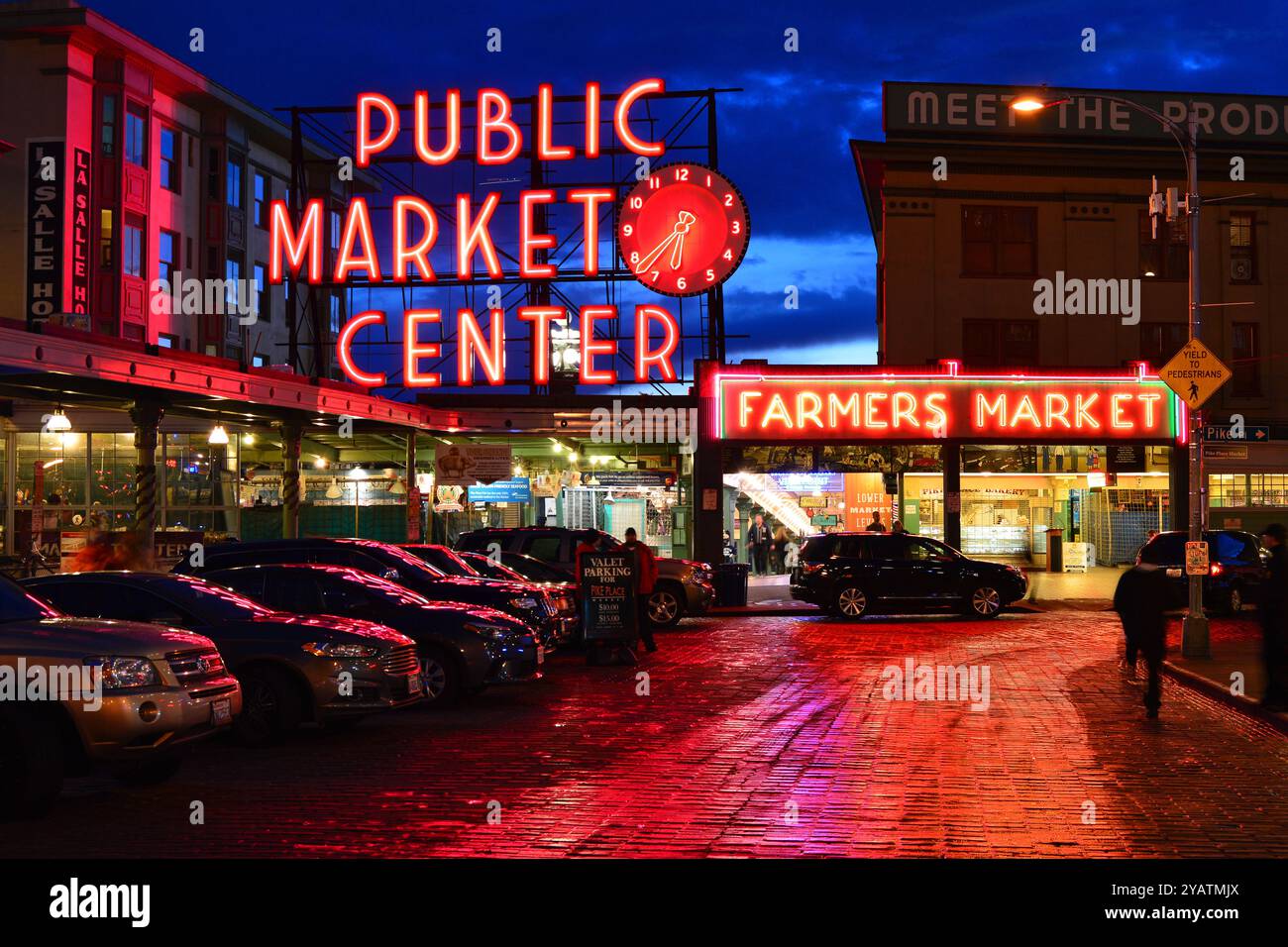 Die Lichter des Pike Place Market in Seattle spiegeln sich in den regnerischen Straßen Stockfoto