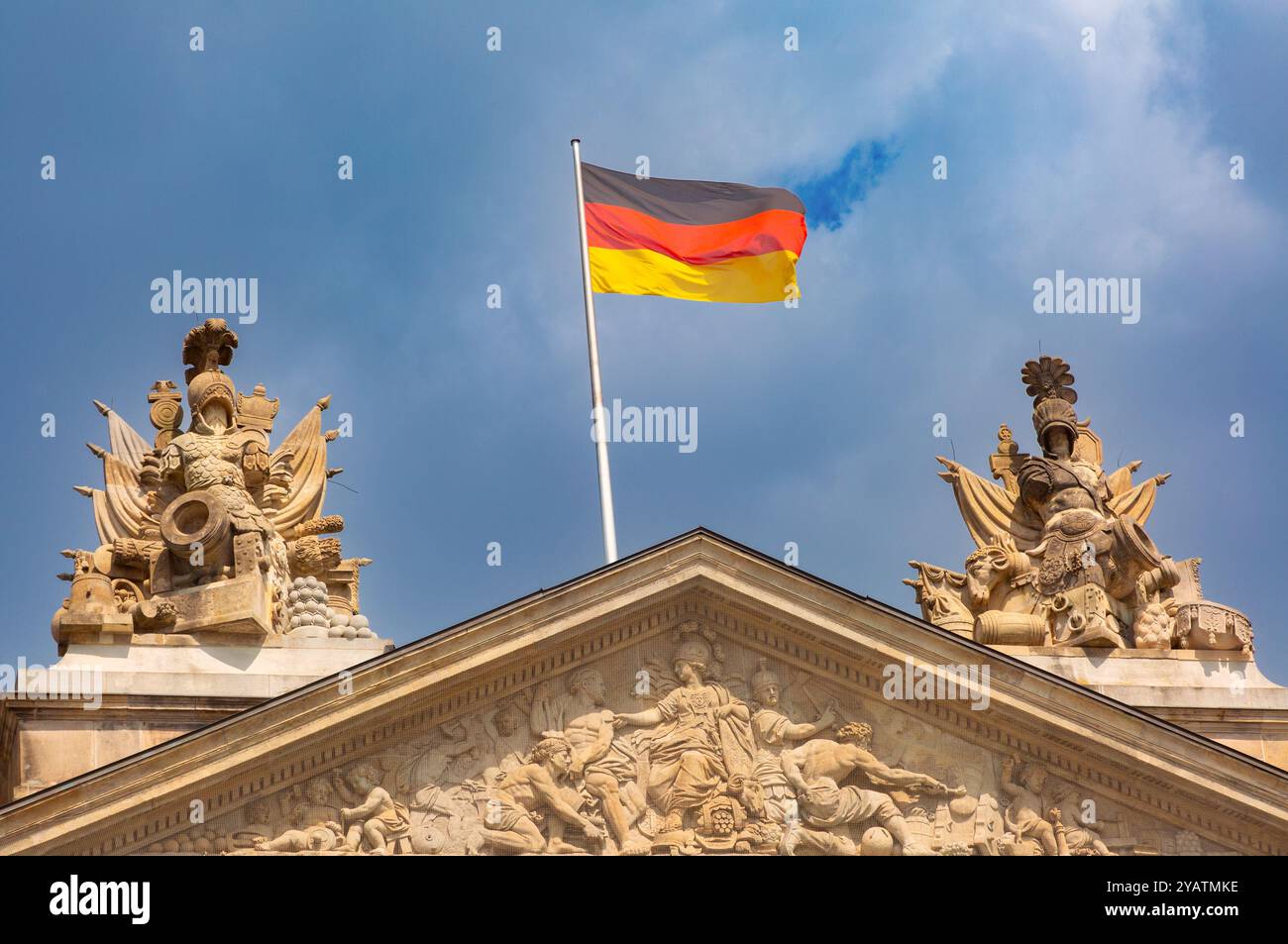 Nahaufnahme der deutschen Nationalflagge auf historischem Gebäude vor bewölktem Himmel in Berlin. Stockfoto