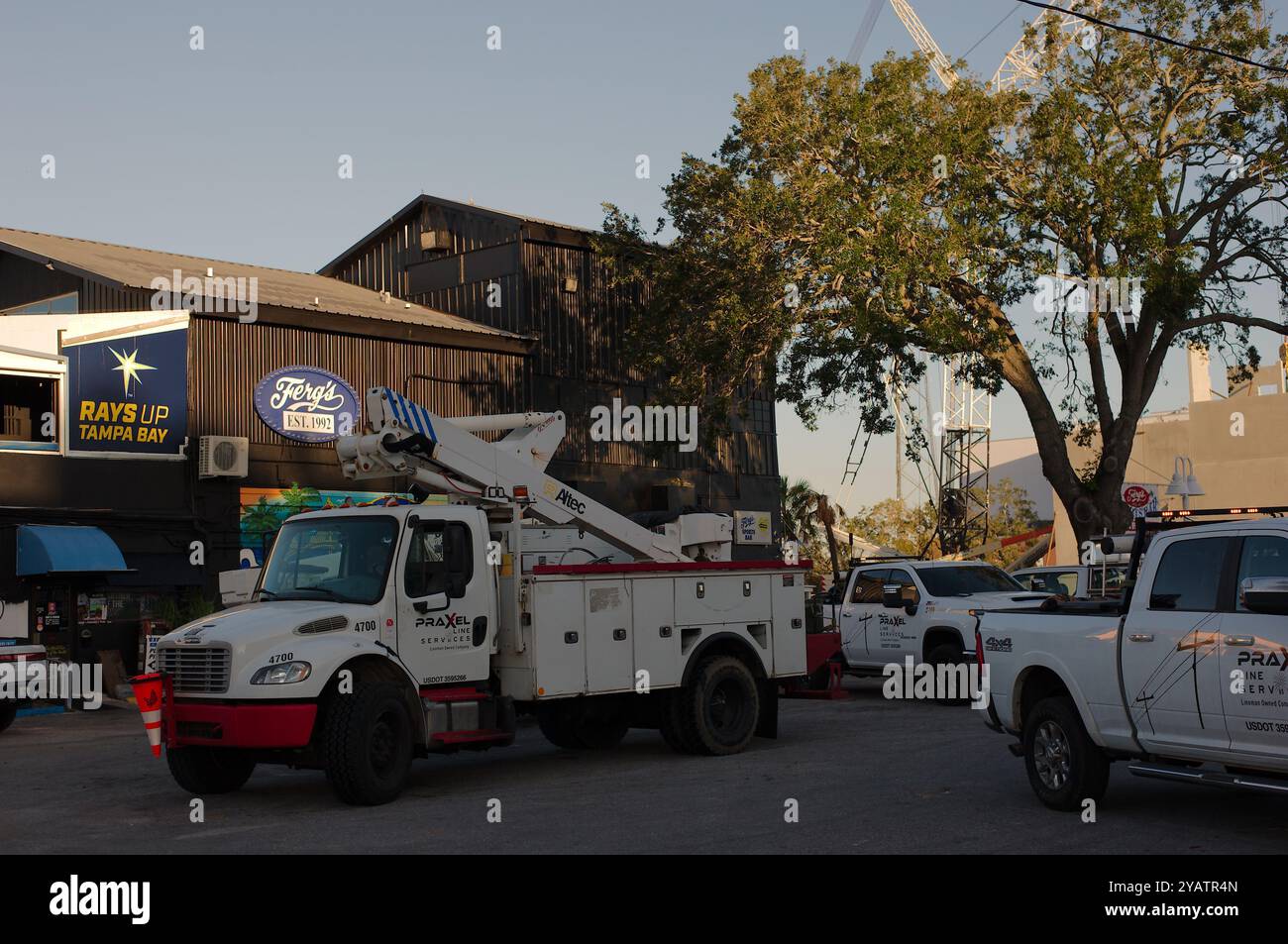 Nur zur redaktionellen Verwendung am 14. Oktober 2024 Ferg's Sports Bar. St. Petersburg, FL, USA. Nutzfahrzeuge auf dem Parkplatz nach Hurrikan Milton. Blauer Himmel Stockfoto