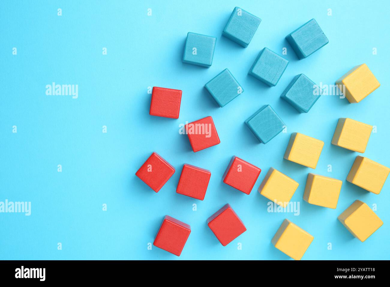 Viele bunte Würfel auf hellblauem Hintergrund, flache Lagen Stockfoto