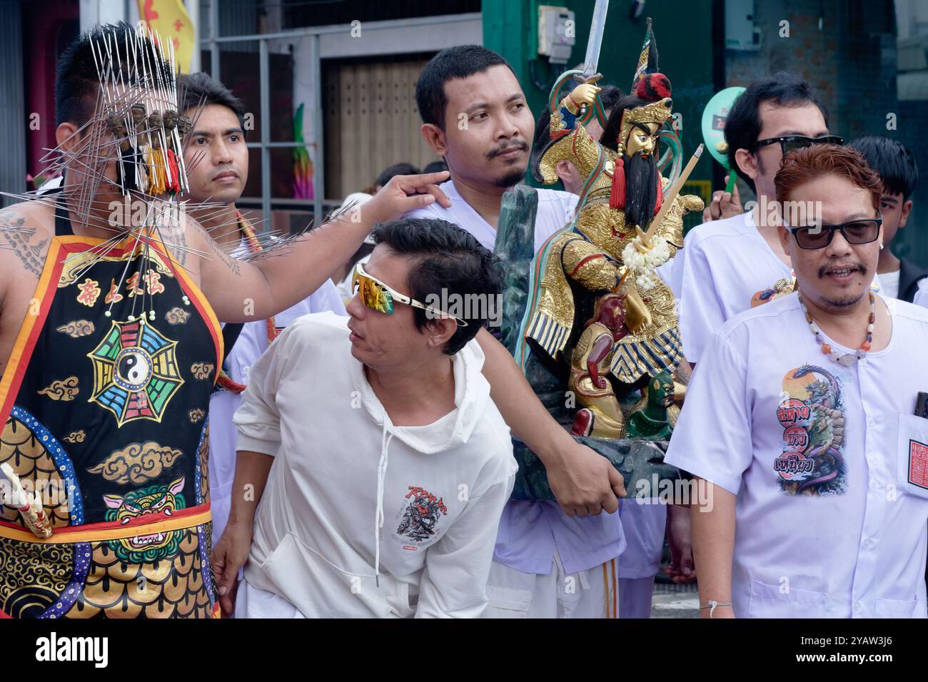 Während des vegetarischen Festivals in Phuket Town, Thailand, zeigt ein mAh Song oder ein spirituelles Medium eine Vielzahl von Spitzen, die durch seine Gesichtshaut durchbohrt werden Stockfoto