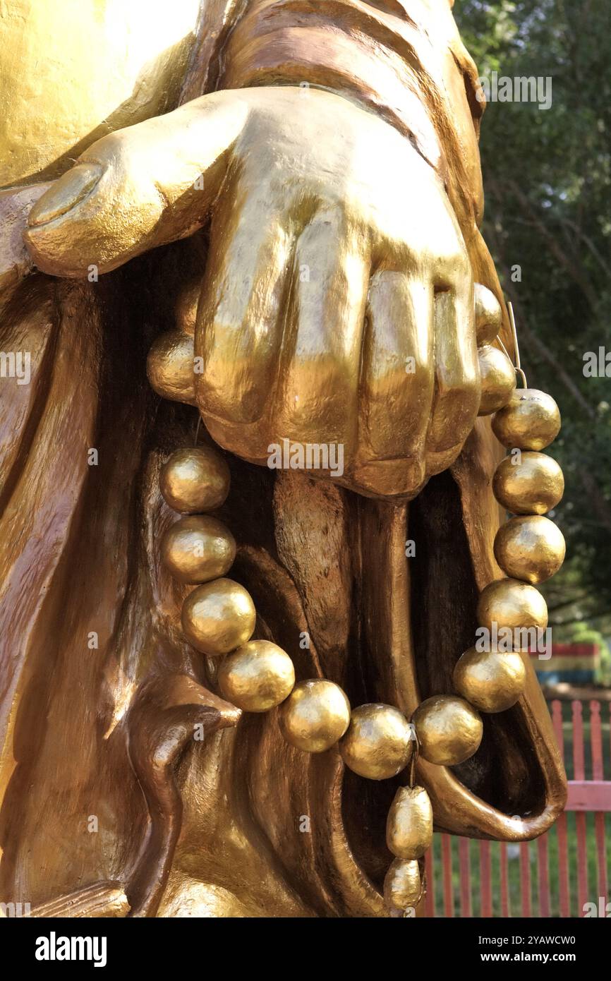 Details zur lachenden Buddha-Statue, die die linke Hand mit Gebetskegeln im Pulo Kemaro (Insel Kemaro) Tempelkomplex in Palembang, Indonesien zeigt. Stockfoto