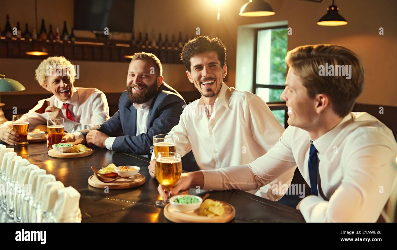 Männer erzählen Geschichten und lachen an der Bar, jedes mit Bier in der Hand, was perfekte Momente der Verbindung und gemeinsamen Erfahrung schafft. Stockfoto