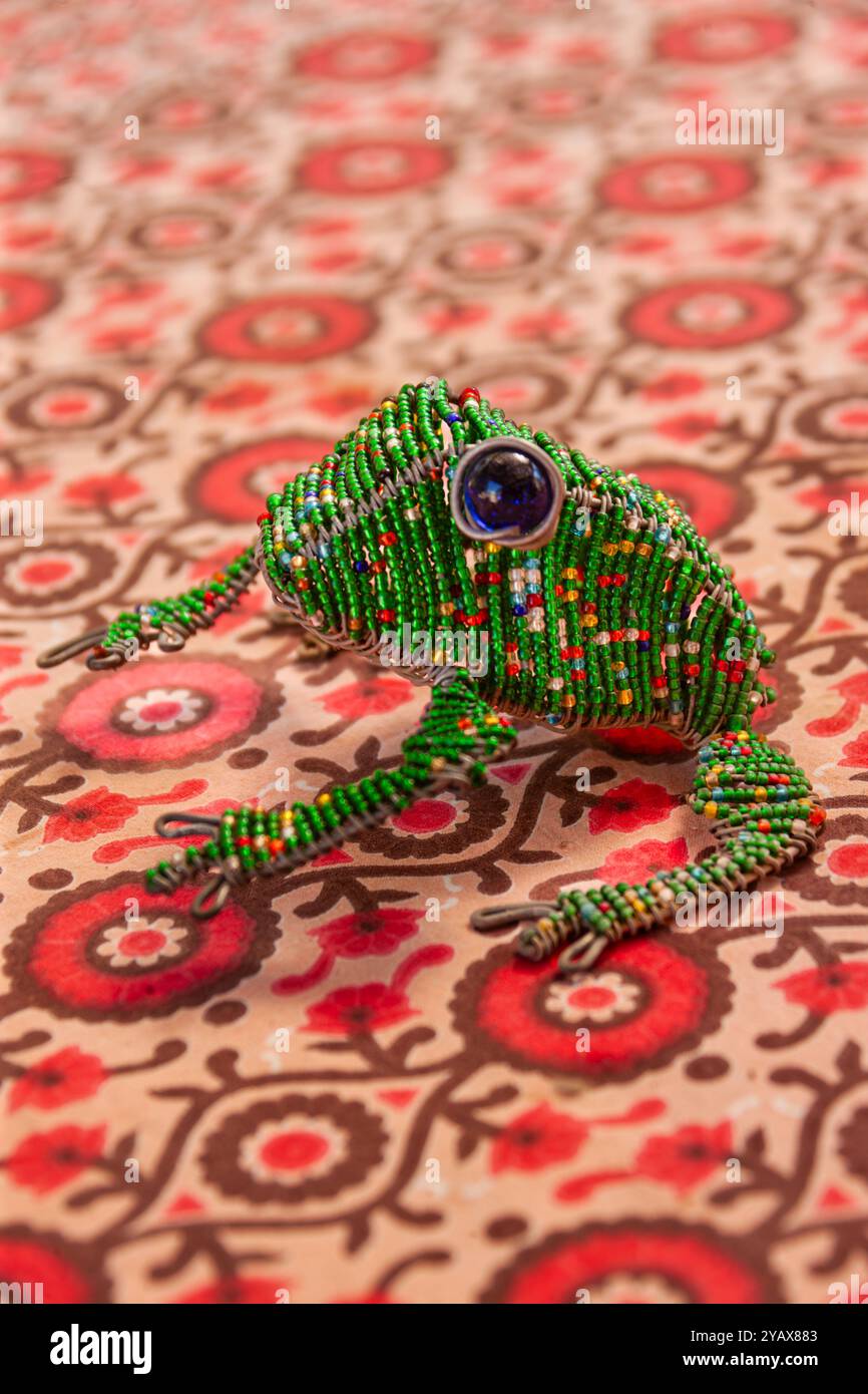 Krötenfrosch, afrikanische Draht-Kunst, mit bunten Perlen, Tischdecke mit Blumenmustern Stockfoto
