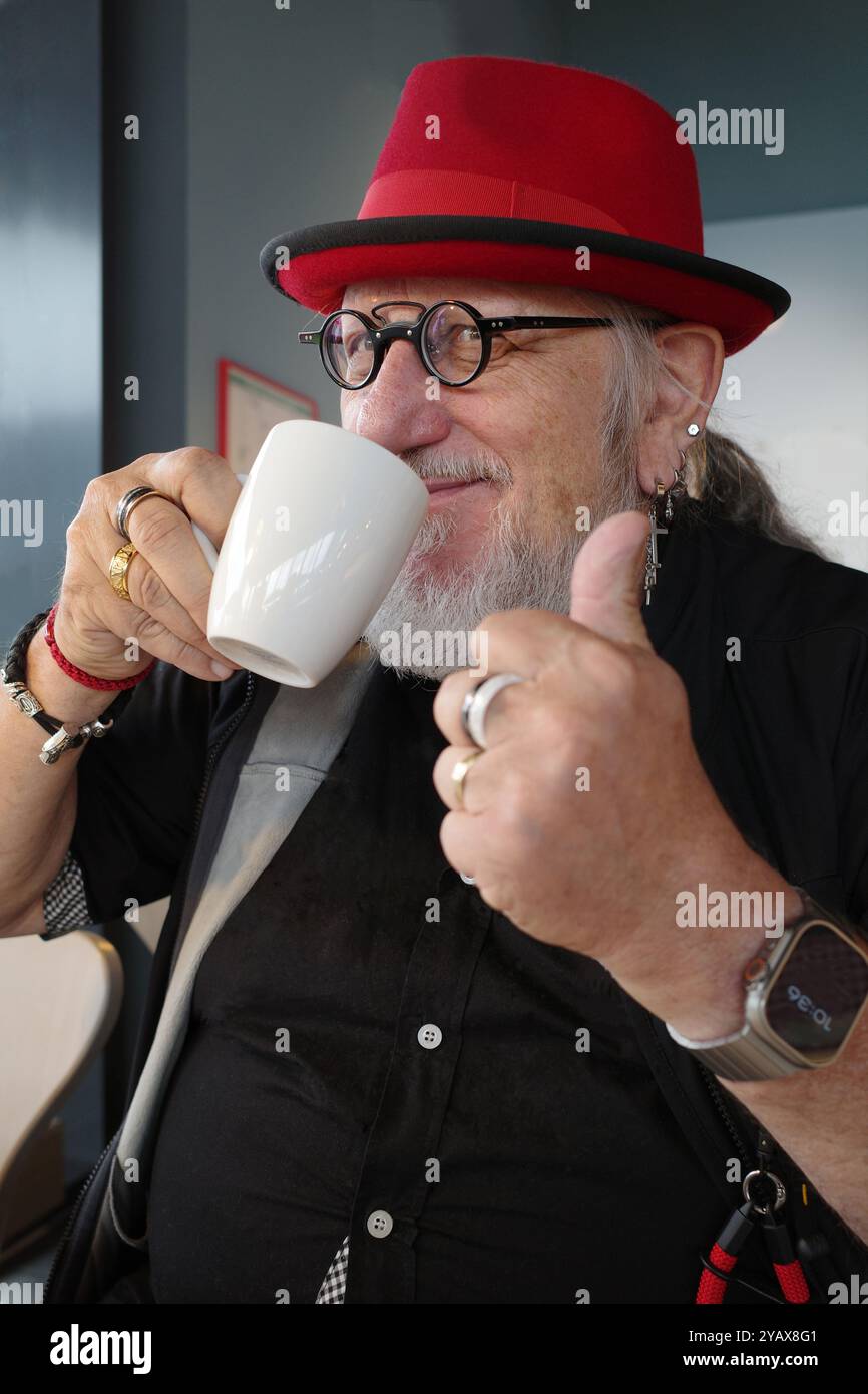 Ein älterer Mann mit einem starken individuellen Geschmack genießt seinen Kaffee Stockfoto