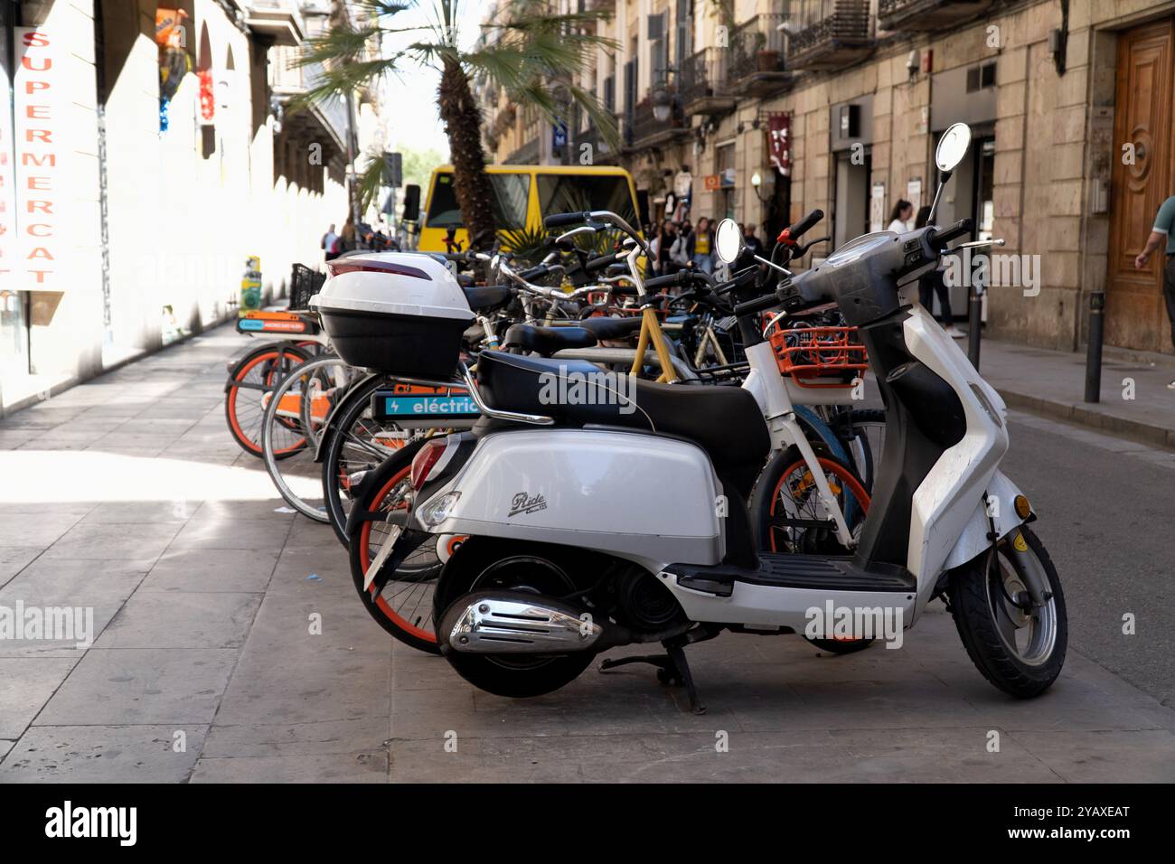 Parkplatz für Roller und Fahrräder auf der Straße von Barcelona Stockfoto