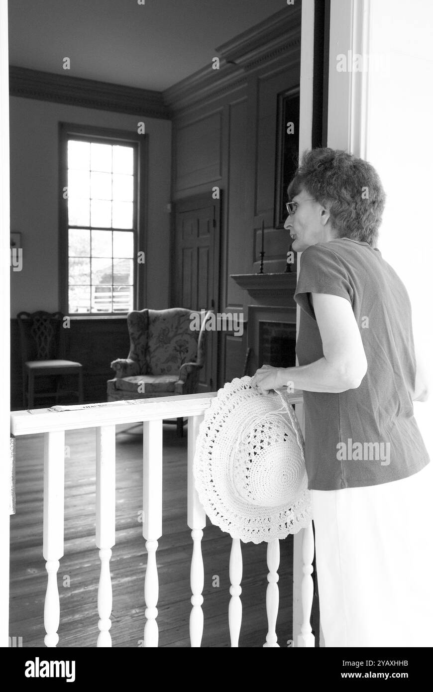 Eine ältere Frau, 55 bis 60 Jahre alt, die sich eine historische Ausstellung in einem alten Haus im Revolutionary war Park in Camden, South Carolina, USA ansieht. Stockfoto