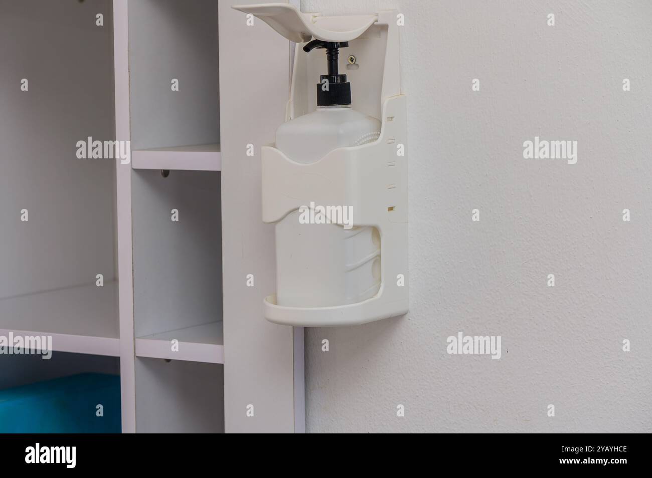Ein schlanker Spender ist sicher an der Wand eines aufgeräumten Raums angebracht und unterstreicht die Wichtigkeit von Sauberkeit und Hygiene in alltäglichen Räumen Stockfoto