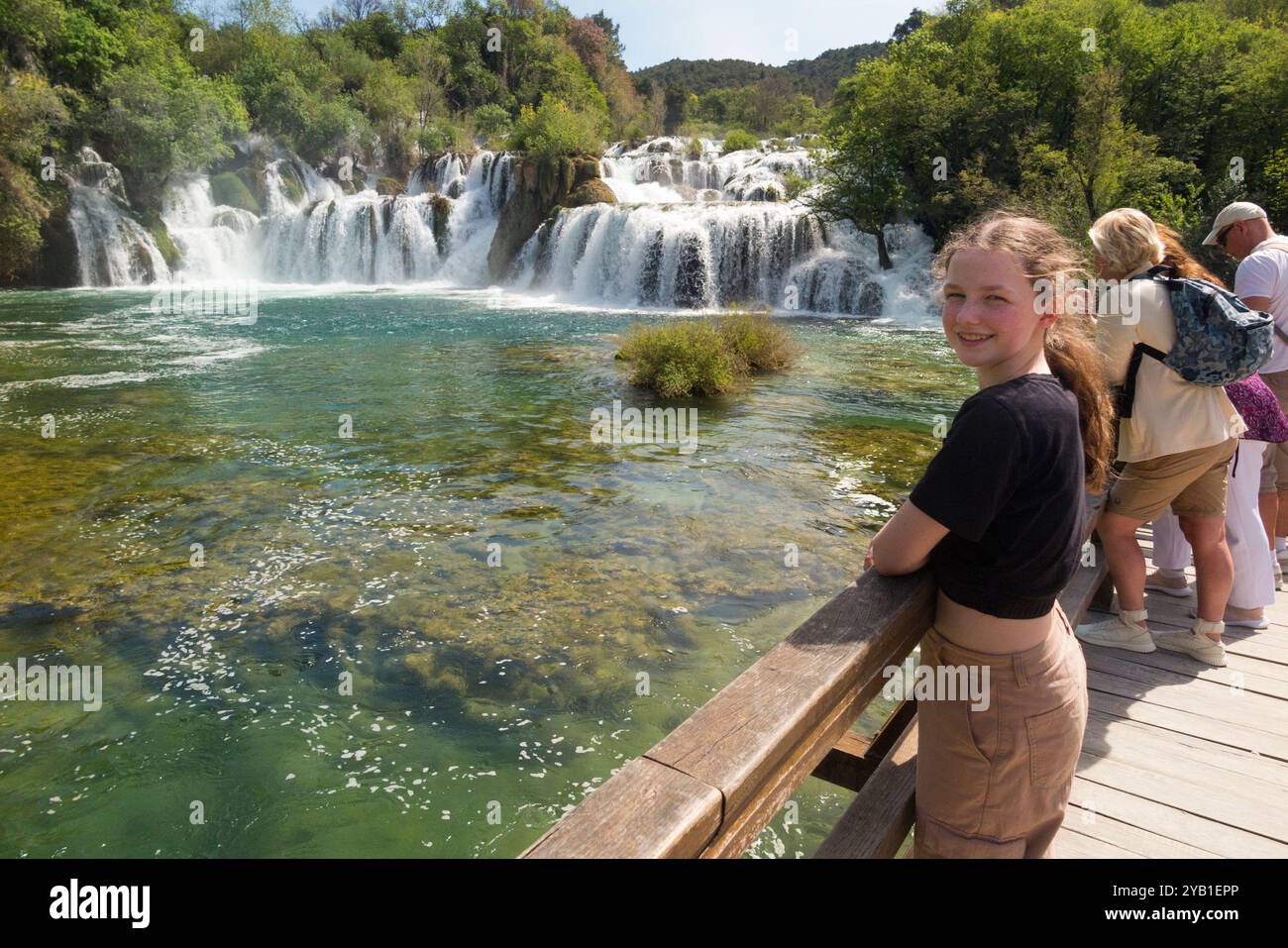 Kind Teenager Touristen / Touristen / Besucher / Mädchen / 12 / 13 Jahre posiert auf der Brücke am spektakulären Wasserfall im Krka Nationalpark. Kroatien. (138) Stockfoto
