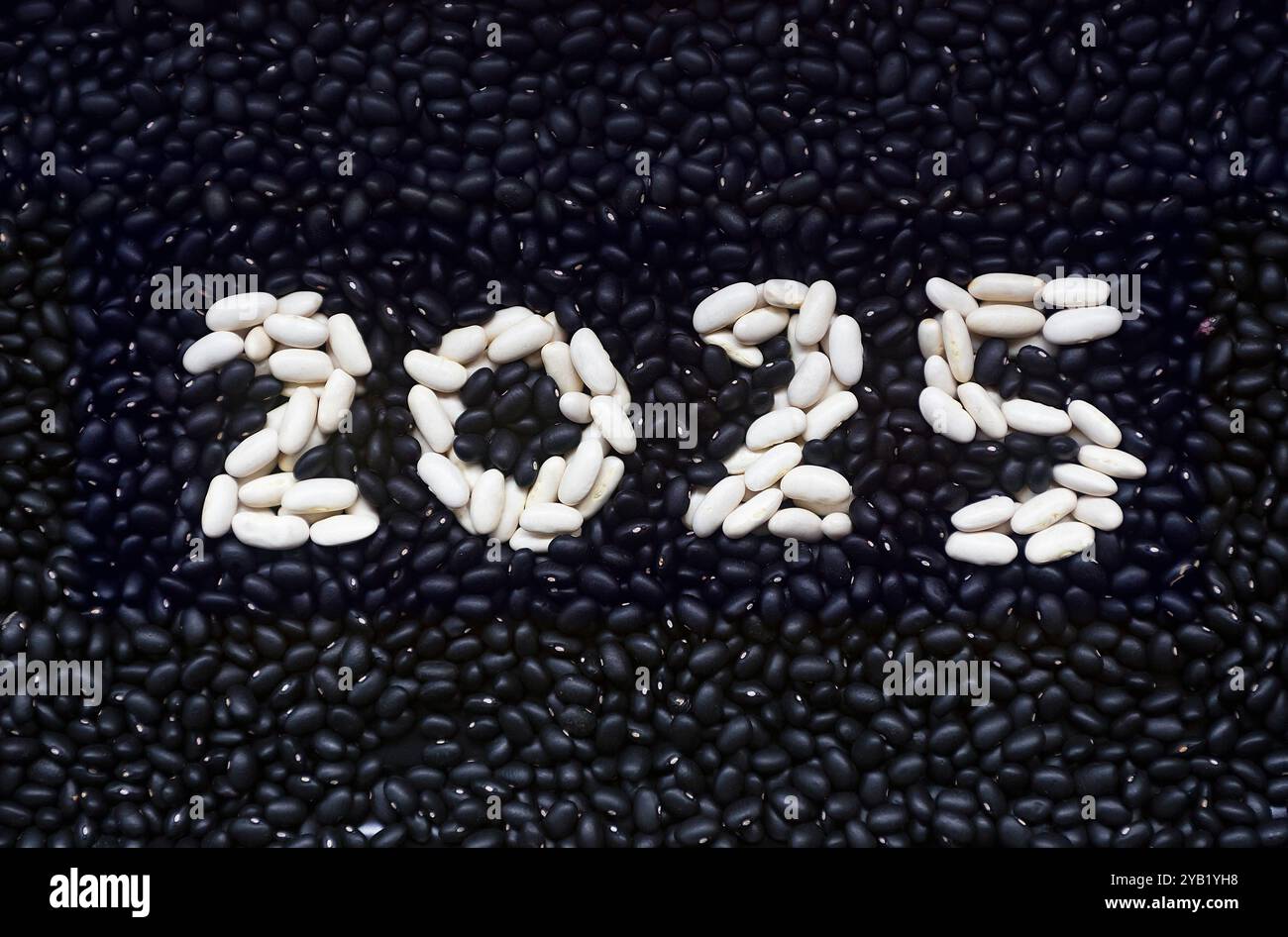 Happy New Year 2025 geschrieben mit schwarzen und weißen Bohnen Stockfoto
