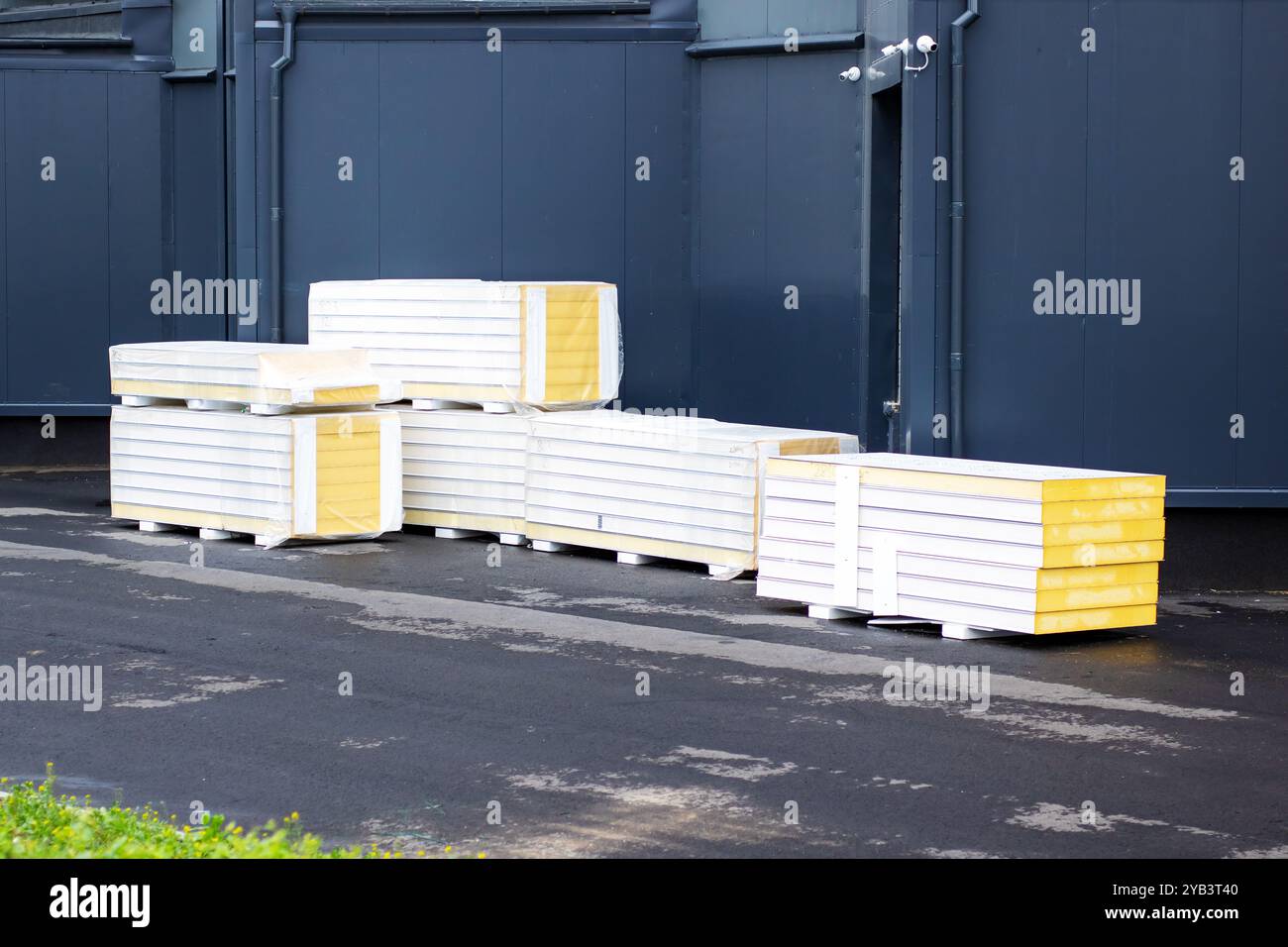 Die sauber angeordneten weißen Paletten mit leuchtenden gelben Akzenten heben sich wunderbar von einem dunklen Hintergrund ab Stockfoto