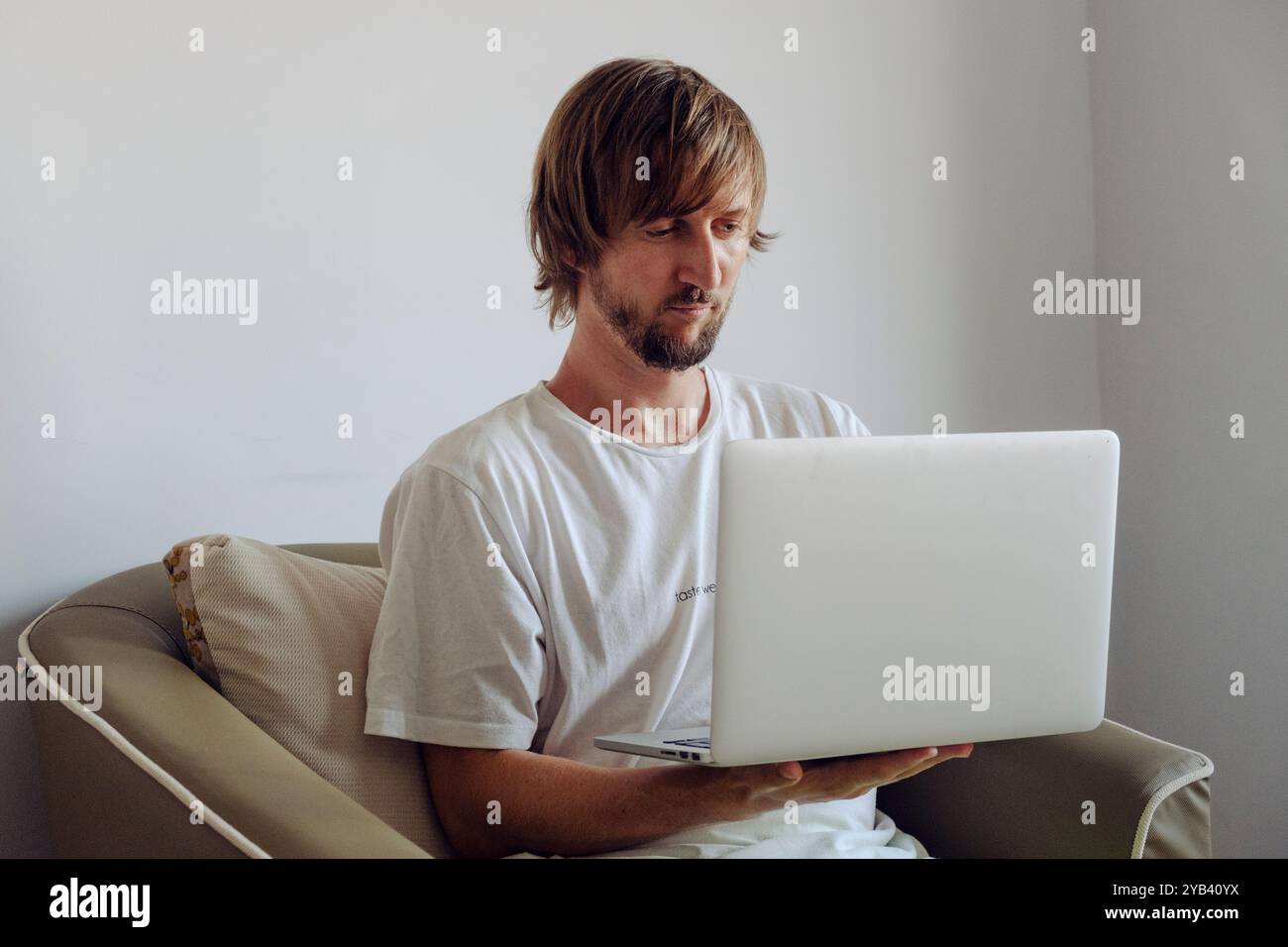 Porträt eines Mannes mit Bart, der an einem Laptop arbeitet Stockfoto