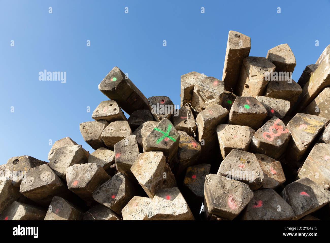 Nahaufnahme eines Haufens verlassener Betonschwellen vor einem blauen Himmel. Stockfoto