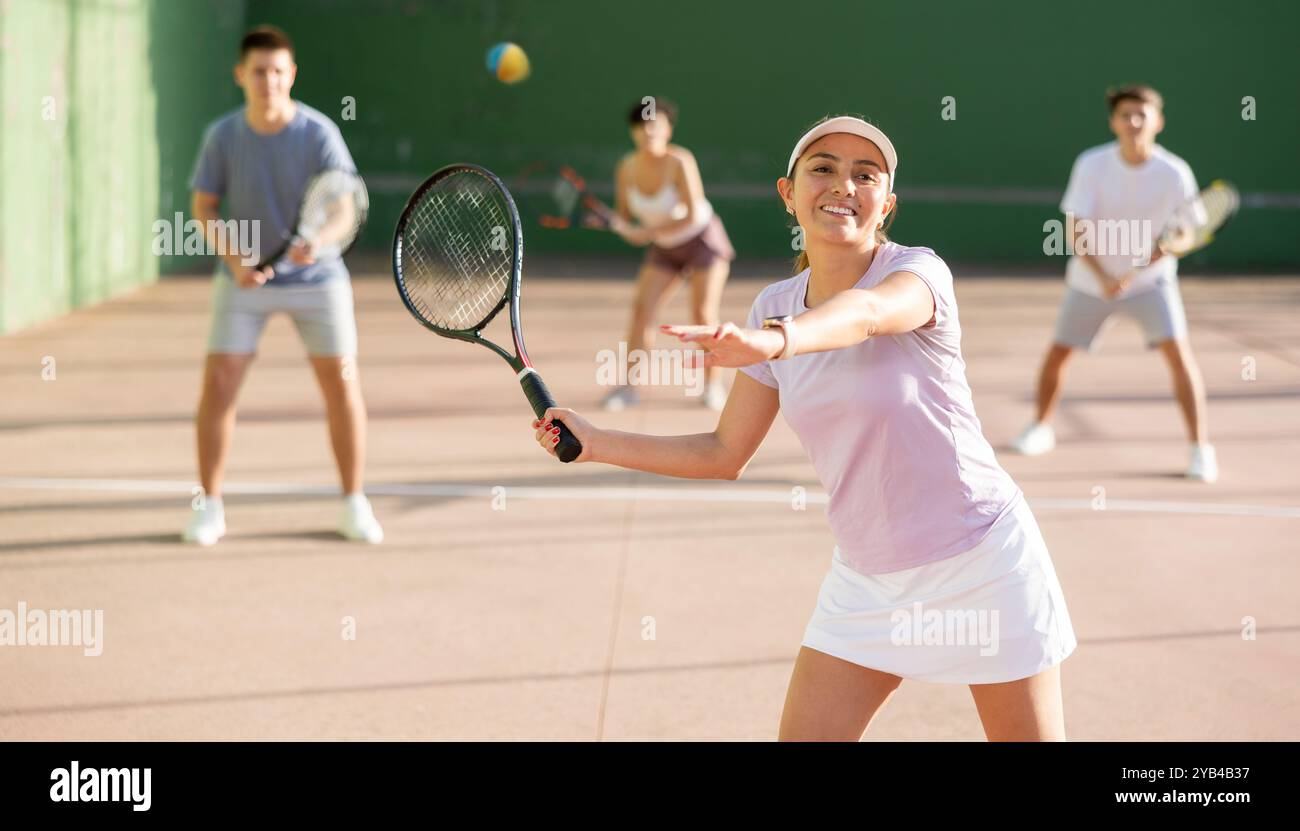 Frau serviert Ball während Frontenis Spiel im Freien Stockfoto