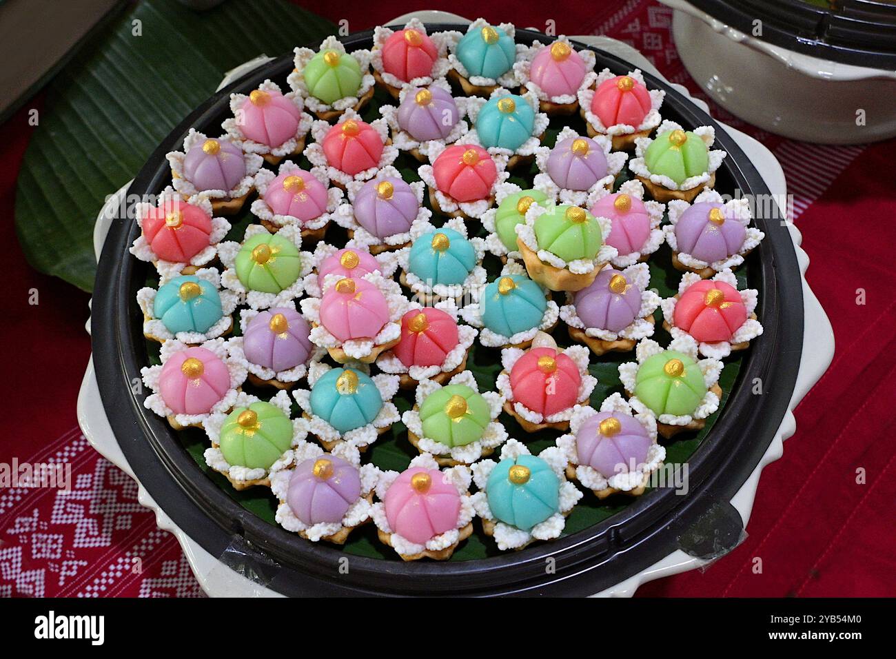 Platte mit bunten und einzigartig aussehenden Khanom Mongkutphet (Diamond Crown) thailändischen Desserts, dekoriert mit Kristallzucker Stockfoto