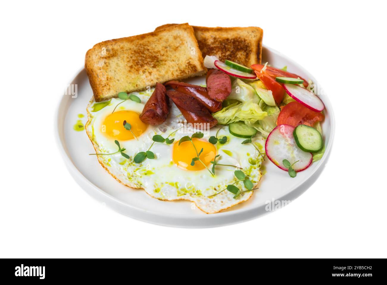 Gesundes englisches Frühstück mit Spiegeleiern, Würstchen, Toast und Salat in weißer Platte auf weißem Hintergrund Stockfoto