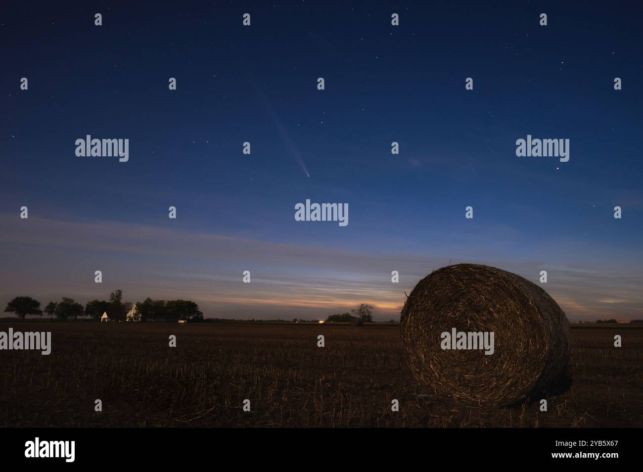 Foto des Kometen C/2023 A3 Tsuchinshan-Atlas nach Sonnenuntergang über flachen landwirtschaftlichen Feldern, beleuchtet durch das Licht des Supermondes auf der oposittischen Seite von t Stockfoto