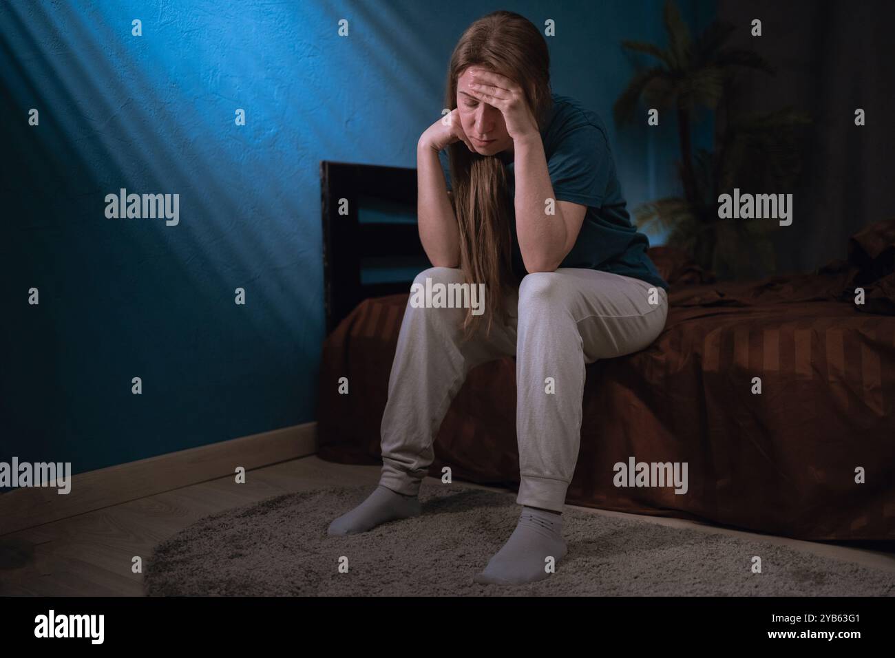 Schlaflosigkeit Frau bedeckt Gesicht sitzend auf dem Bett durch müde und erschöpft vom gestörten Schlaf im Schlafzimmer in der Nacht. Kopierbereich Stockfoto