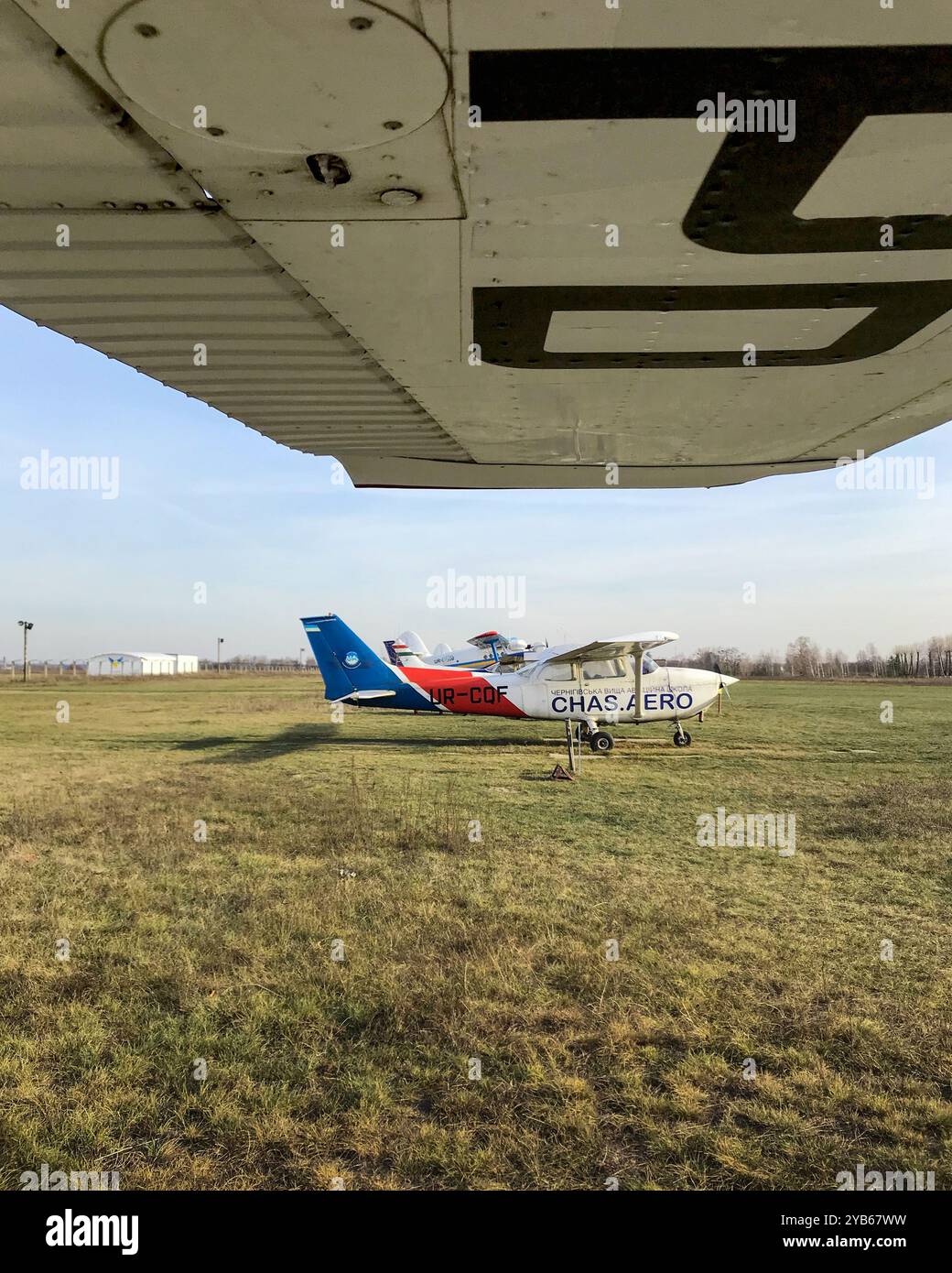 Lokaler Flugplatz mit kleinen Flugzeugen. Reihe von leichten Flugzeugen auf Gras am Spätherbsttag. Stockfoto