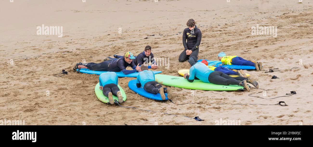Ein Panoramabild von Surflehrern, die Surflehrern am Fistral Beach in Newquay in Cornwall in Großbritannien unterrichten. Stockfoto