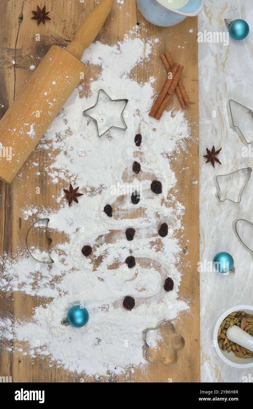 Tisch mit Blick von oben in der Küche, Vorbereitungen für Weihnachten. Mehl, Gewürze, Nudeln, Milch, Keksschneider auf einem Tisch. Stockfoto