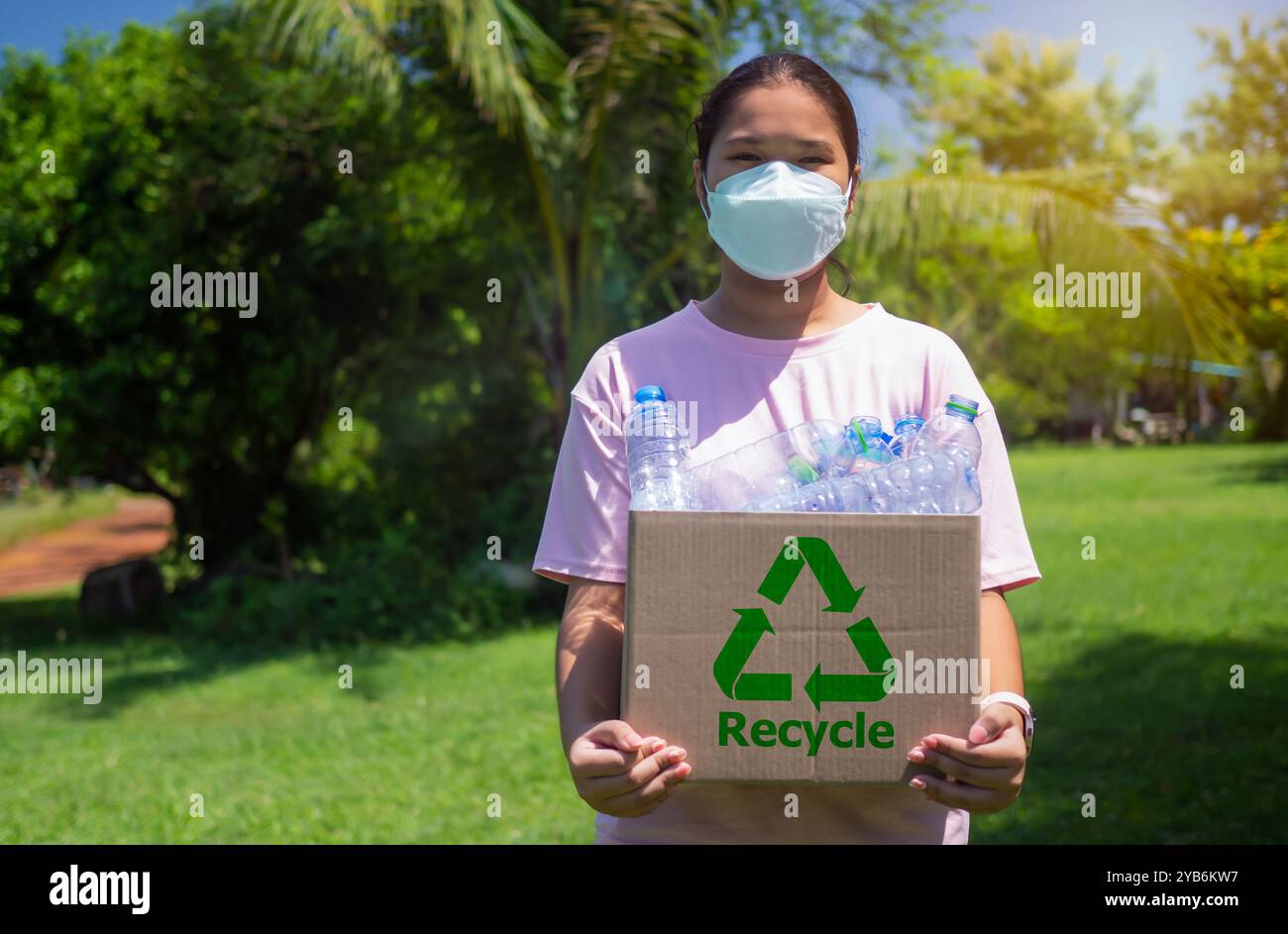 Frau sammelt Müll und hält einen Papierkorb mit Plastikflaschen im Freien, Recycle Concept, Plastic-free, Junk Food Plastikverpackung, R Stockfoto