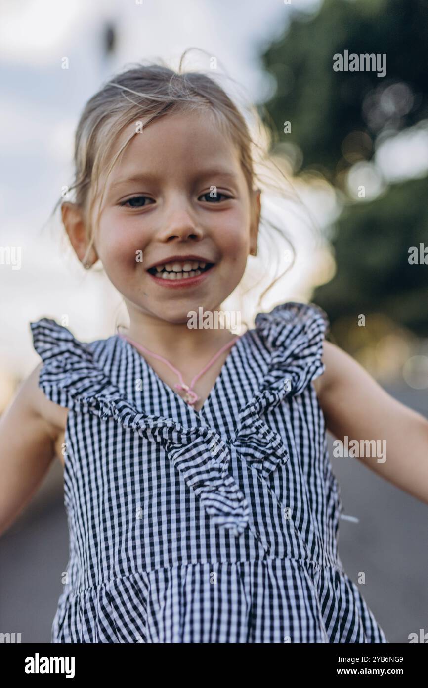 5 Jahre altes glückliches kleines Mädchen, das mit großem Lächeln und Lachen die Vorderzähne zeigt. Hochwertige Fotos Stockfoto