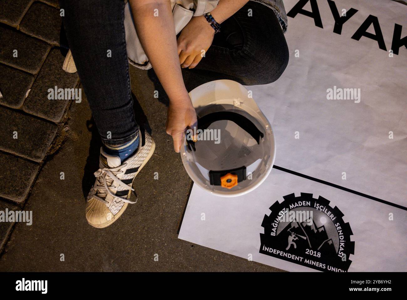 Ein Demonstrant unterstützt das Sit-in, indem er den Schutzhelm eines Bergarbeiters hält, der während des Protestes gesehen wurde. Die Bergbauarbeiter von Fernas im Stadtteil Soma in Manisa wurden von ihren Arbeitsplätzen entlassen, weil sie sich gewerkschaftlich organisieren wollten. Am 14. Oktober traten die Arbeiter in den Hungerstreik von Manisa in die Hauptstadt Ankara. Am nächsten Tag in der Nacht sperrte die Polizei die Arbeiter ein. Diese Aktion der Arbeiter fand in der ganzen Türkei Reaktion. Izmirs politische Parteien und Gewerkschaften organisierten eine Sit-in- und Pressemitteilung, die die Bergarbeiter unterstützte. (Foto: Murat Kocabas/SOPA Images/SIPA USA) Stockfoto