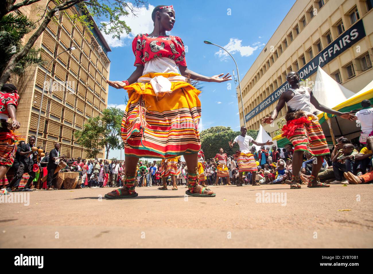 Eine Frau spielt während des Karnevals in Kampala einen traditionellen Tanz auf der Straße Stockfoto