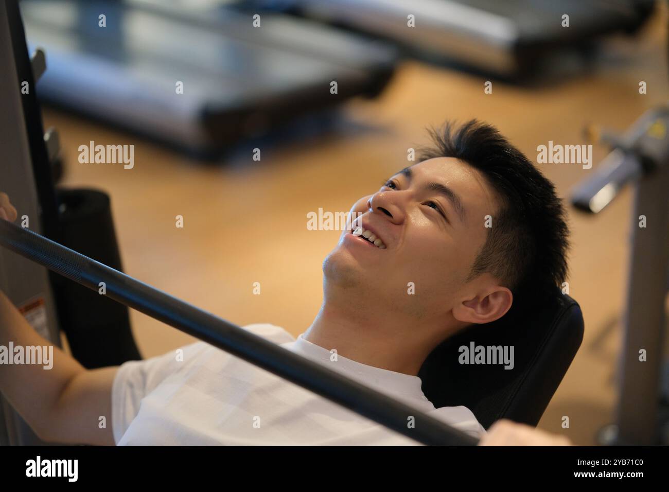 Lächelnder, gutaussehender asiatischer junger Mann, Workout und Training im Fitnessstudio Stockfoto