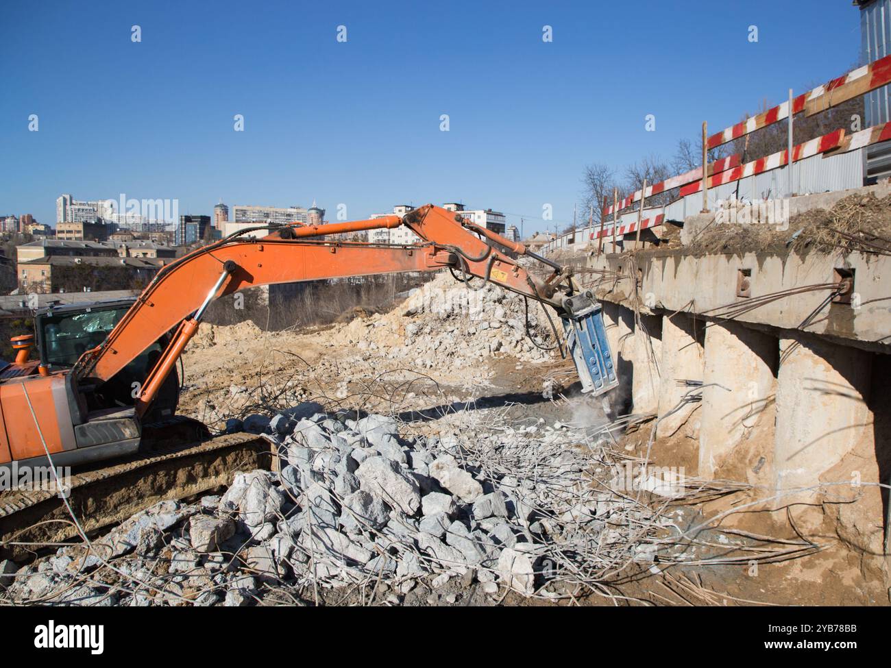 Baumaschine um Betonfragmente und Metallbewehrungen herum Stockfoto