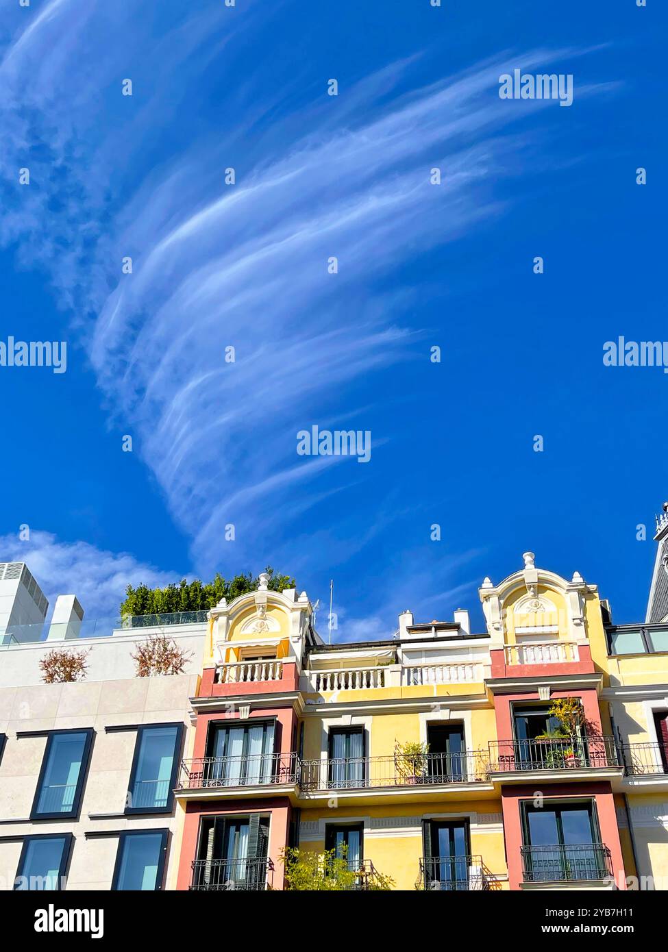 Fassade von Häusern und Wolken. Madrid, Spanien. - Smartphone-aufgenommenes Stockfoto