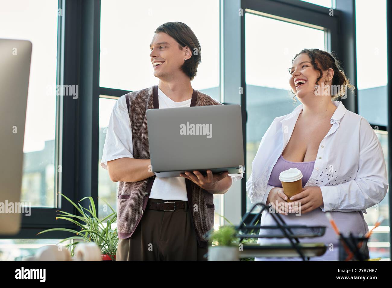 Eine junge Frau in Übergröße lacht mit ihrem männlichen Freund, während sie eine Kaffeetasse hält. Stockfoto