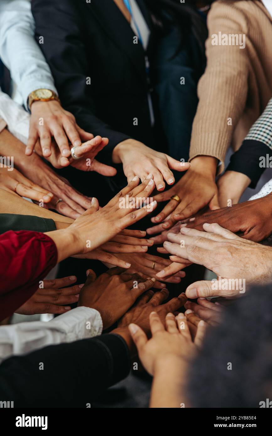 Multiethnische Teamarbeit mit verschiedenen Händen, die zusammenarbeiten und Einheit und Zusammenarbeit in einer Gruppe darstellen. Dieses Bild zeigt ein Gefühl der Einheit Stockfoto