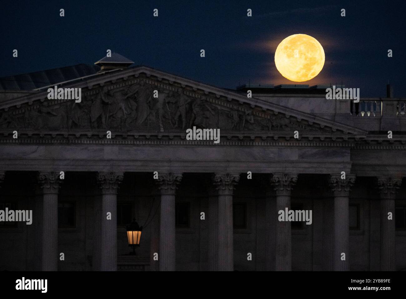 Washington, USA. Oktober 2024. Der Mond des Jägers untergeht am Donnerstag, den 17. Oktober, in Washington, DC, hinter dem Kapitol der USA. 2024. der Vollmond dieses Monats ist der größte Supermond des Jahres. er erscheint größer und heller als ein durchschnittlicher Vollmond, da er näher an der Erde vorbeizieht als sonst in seiner Umlaufbahn. (Graeme Sloan/SIPA USA) Credit: SIPA USA/Alamy Live News Stockfoto