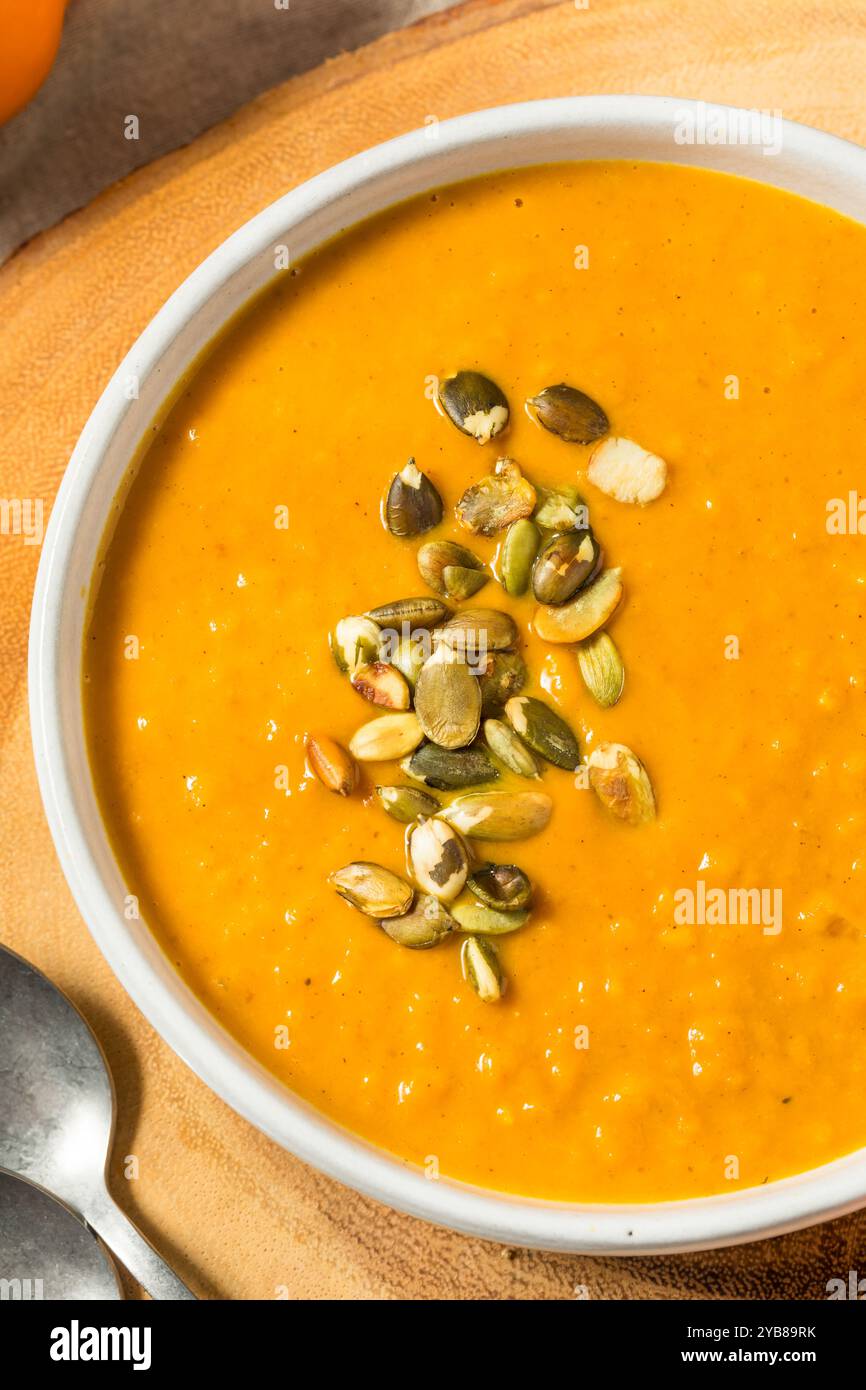 Hausgemachte Herbstkürbis-Suppe mit Creme und Samen in einer Schüssel Stockfoto