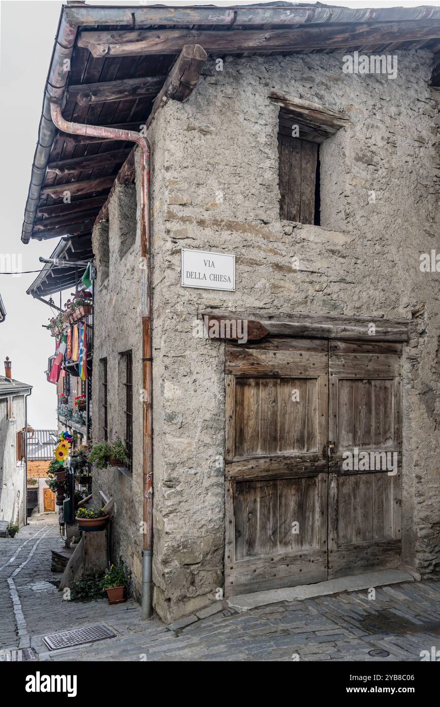 Stadtbild mit altem Eckhaus aus Stein im historischen Bergdorf Valchisone Valley, aufgenommen im hellen Herbstlicht in Usseaux, Turin, Italien Stockfoto