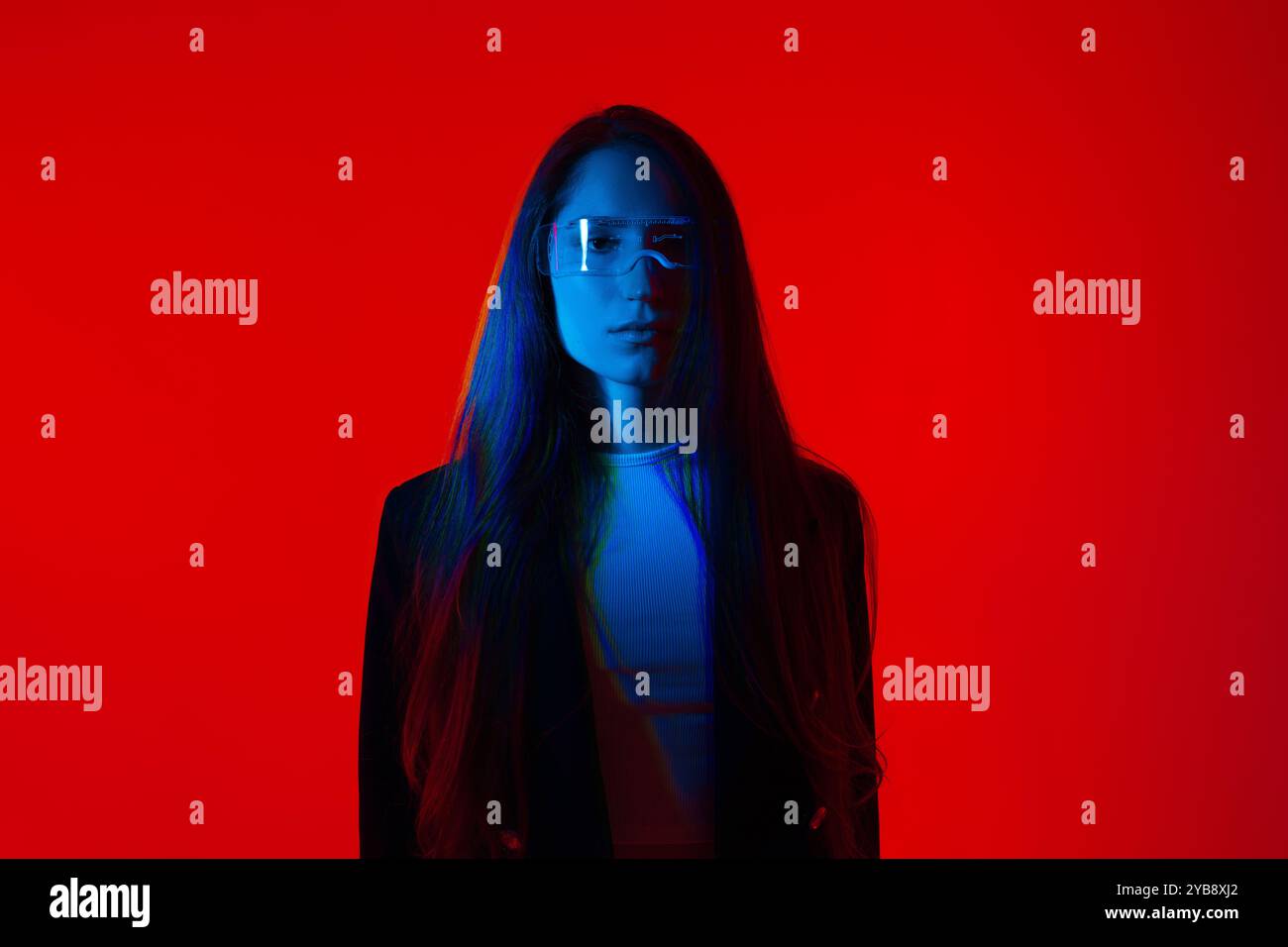 Cyberpunk-Porträt in Futuristic Modern Young Woman with Smart Briasses Standing a Red Glowing Background Stockfoto