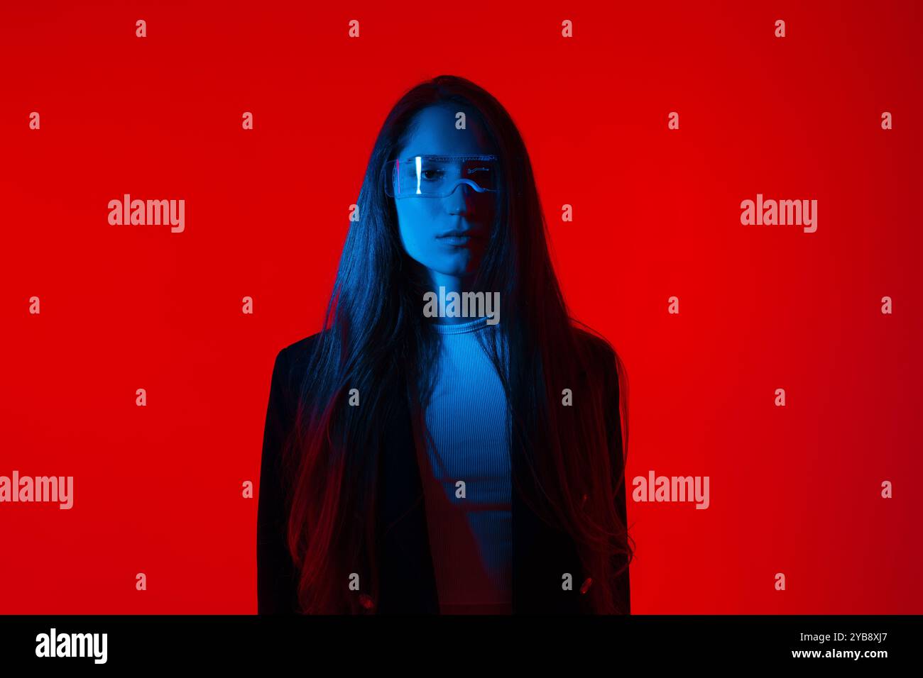 Cyberpunk-Porträt in Futuristic Modern Young Woman with Smart Briasses Standing a Red Glowing Background Stockfoto