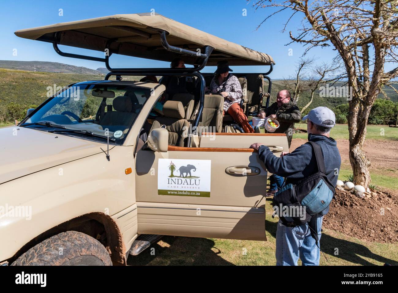 Touristen/Leute, die ein-/aussteigen in ein Safari-Jeep-Fahrzeug im Indalu Game Reserve in Mossel Bay, Südafrika Stockfoto