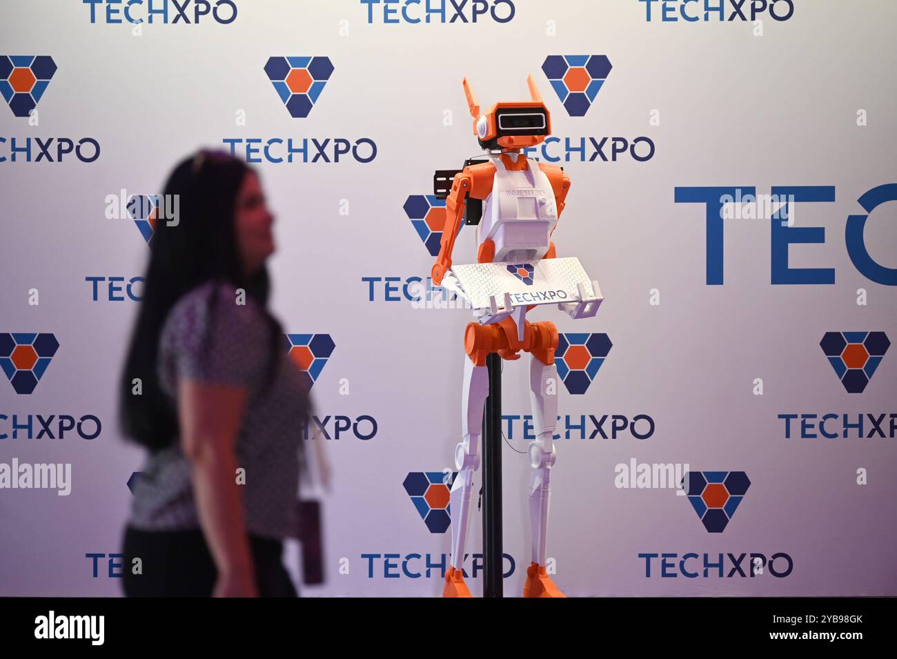 Ta' Qali, Malta. Oktober 2024. Während des Startup-Festivals in Ta' Qali, Malta, kommt am 17. Oktober 2024 eine Frau an einem Roboter vorbei. Das vierte jährliche Startup-Festival in Malta startete am Donnerstag im Malta Fairs and Conventions Centre (MFCC) in Ta' Qali, Zentralmaltas, und zeigte innovative Technologien und das blühende Startup-Ökosystem des Landes. Quelle: Jonathan Borg/Xinhua/Alamy Live News Stockfoto