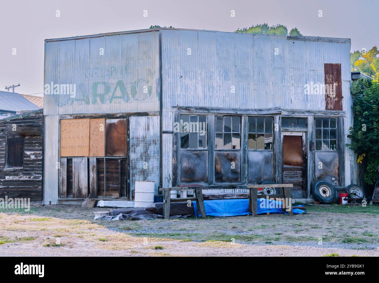 Dies ist ein altes freistehendes Gebäude in der Garage aus Metall und Holz mit alten kaputten Fensterscheiben. Sie sehen eine Eckansicht, 2 Seiten sind oben. Stockfoto