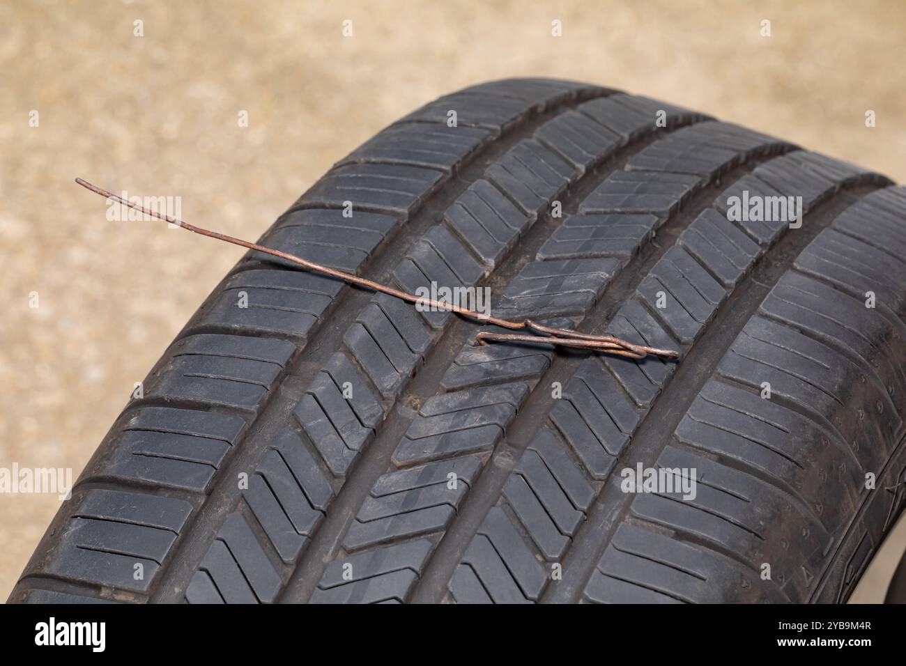 Reifenpannen am Fahrzeug durch Metalldraht. Fahrzeugsicherheit, Reifenpannen, Reifenwartung, Reparatur und Luftdruckkonzept Stockfoto