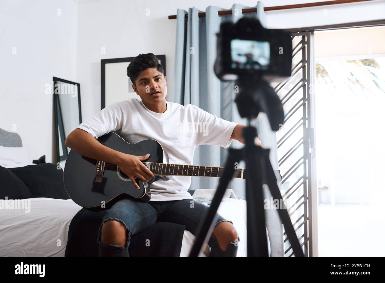 Aufnahme, Influencer und Mann mit Gitarre zu Hause für Live-Streaming, Vlog und soziale Medien. Inhaltsersteller, Kamera und Person mit Musical Stockfoto