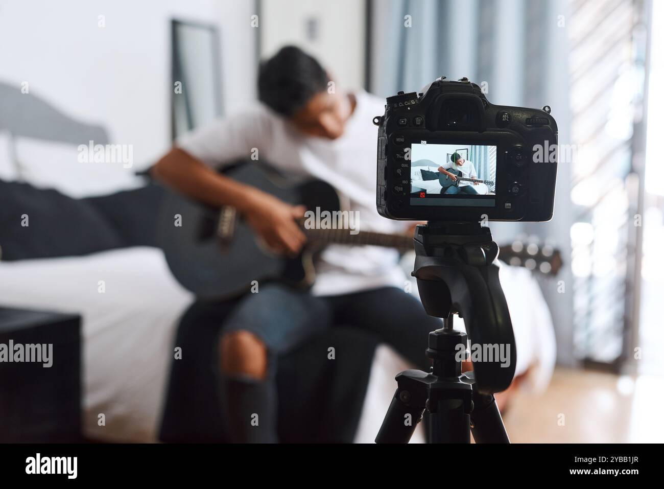 Kamera, Influencer und Mann mit Gitarre zu Hause für Live-Streaming, Musik-Vlog und soziale Medien. Inhaltsersteller, Musiker und Person mit Musical Stockfoto