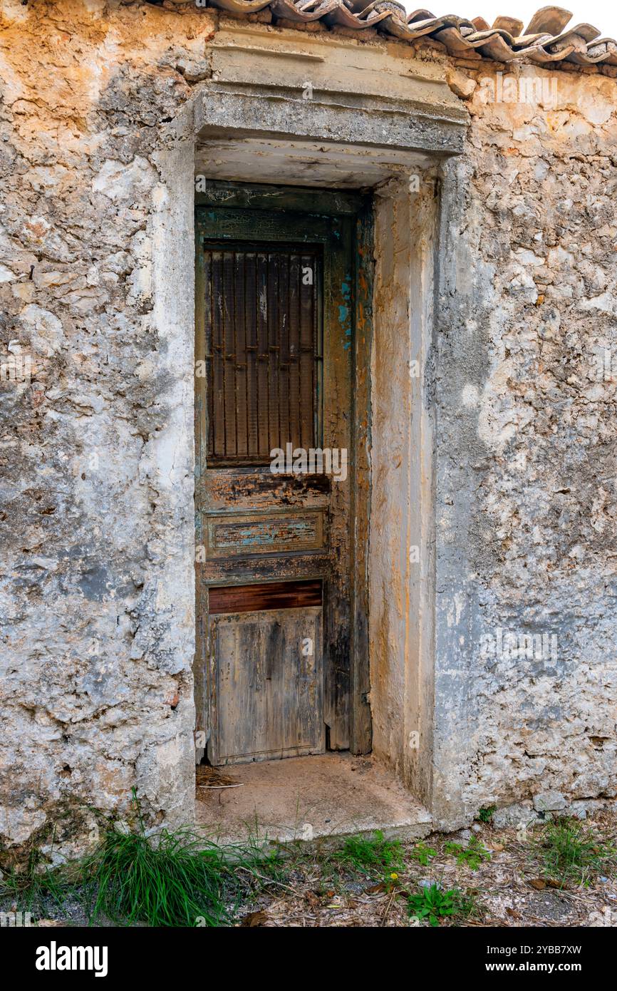 Eine hölzerne Tür eines Dorfes Steinhaus in einem Zustand des Verfalls. Stockfoto