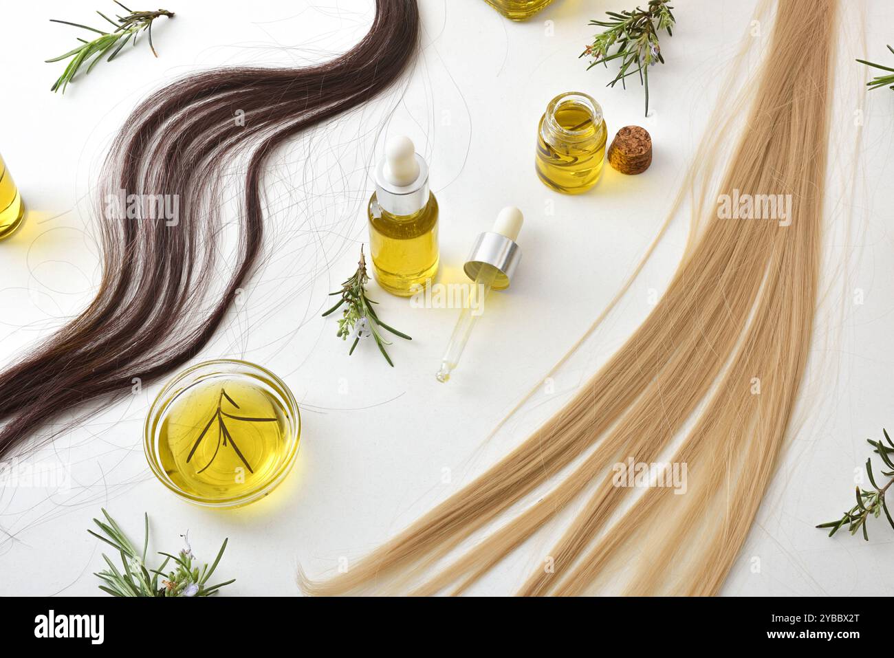 Behälter mit ätherischem Rosmarinöl und Haarsträhnen isoliert auf weißem Tisch zur Haarbehandlung und -Pflege mit Rosmarinzweigen. Draufsicht. Stockfoto
