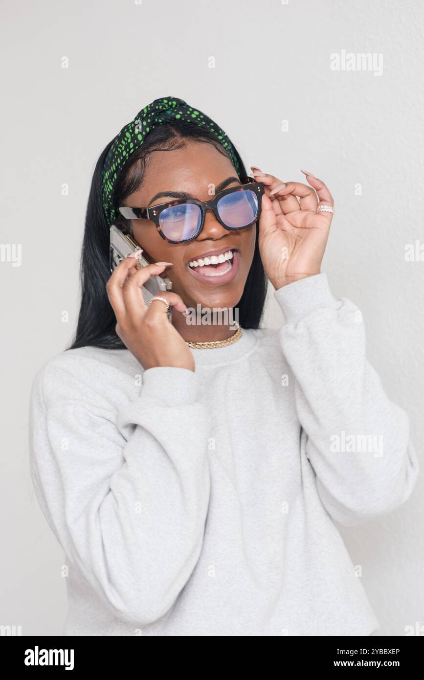 Frau lacht, während sie telefoniert Stockfoto