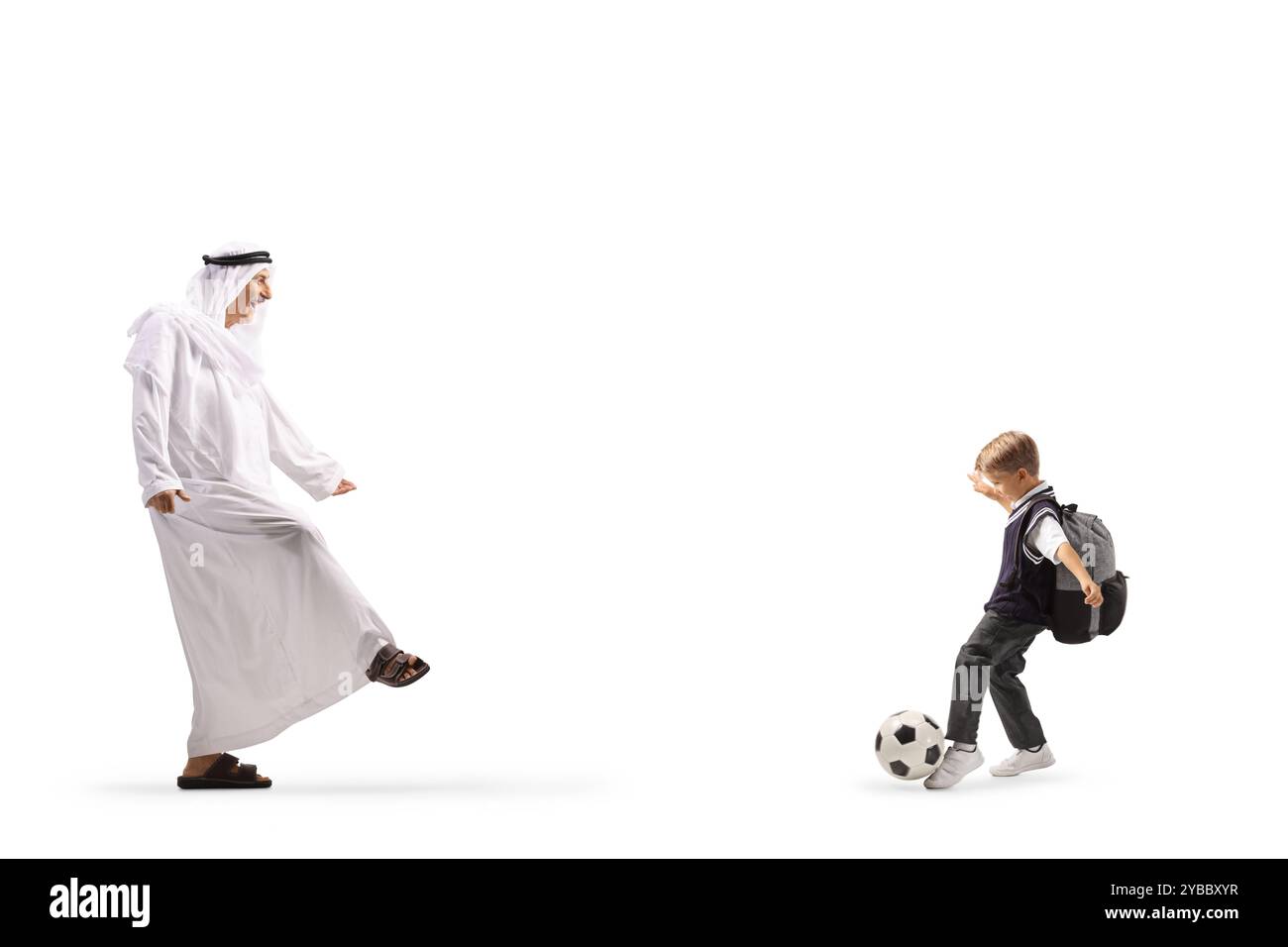 Arabischer Mann in traditionellem Gewand, der mit einem Jungen auf weißem Hintergrund Fußball spielt Stockfoto